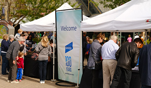 Photo of various Baird associates and their families checking in at tents at the Denver Zoo.