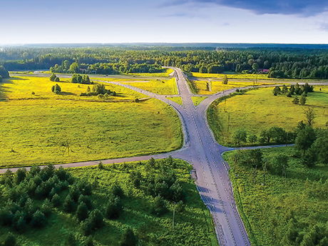 Highway that diverges into three paths surrounded by lush greenery.