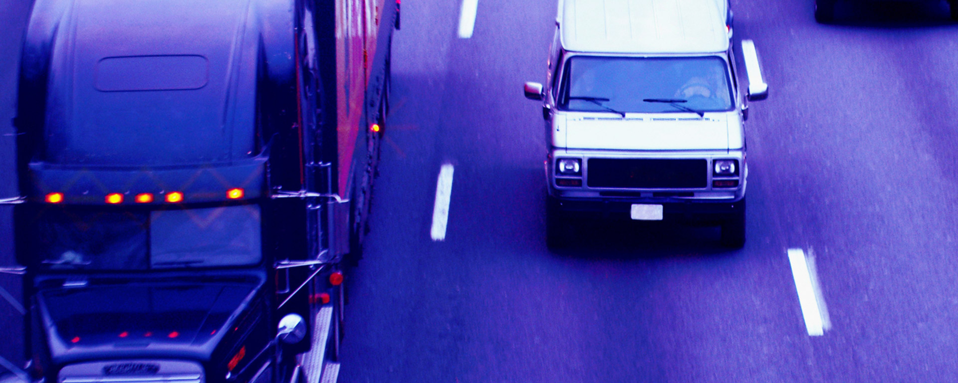Semi-truck and van driving down freeway