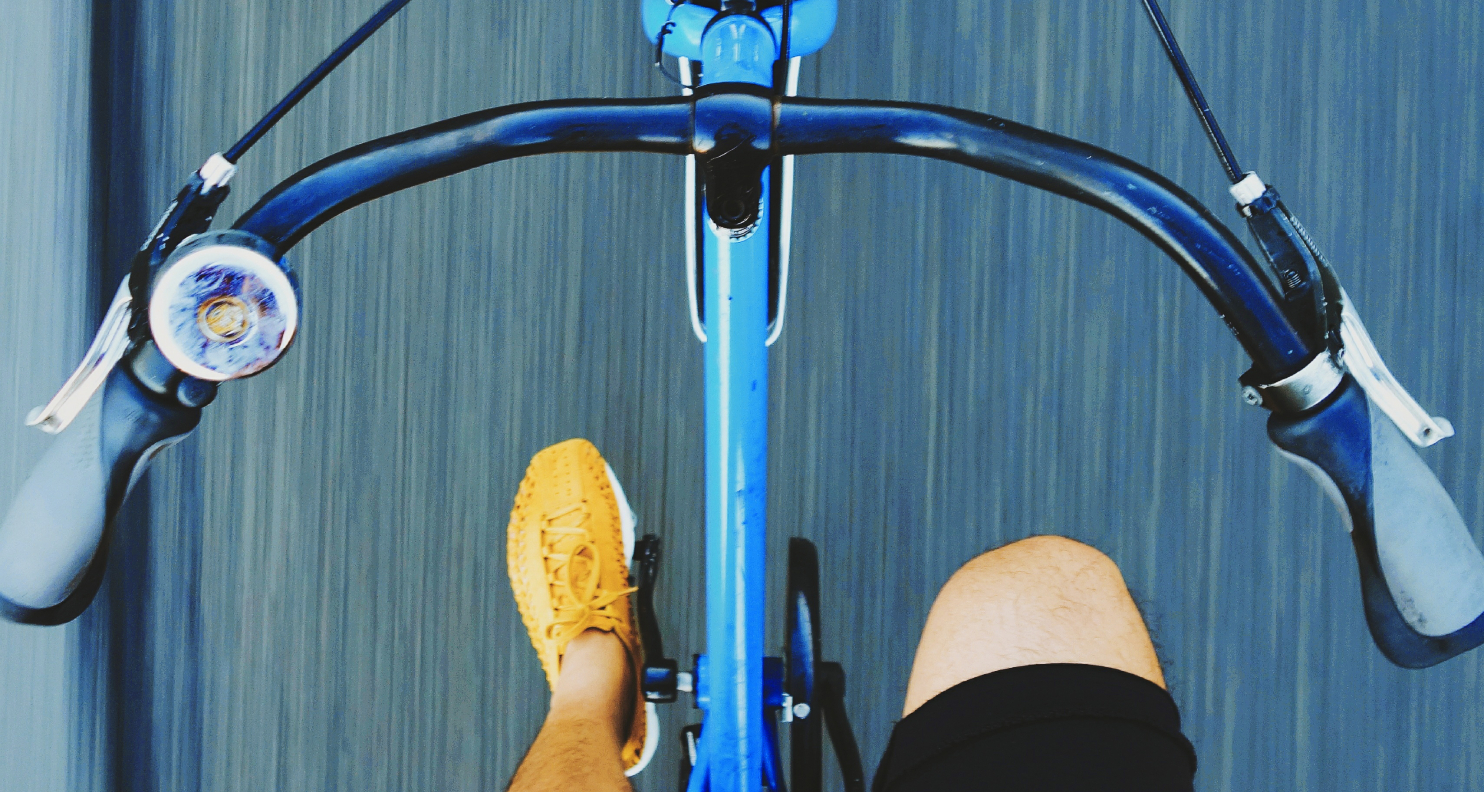 looking down at bicycle handlebars while bicycle is moving.