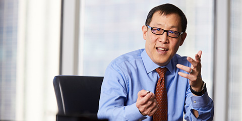 Photograph of Gordon Pan, President of Baird Capital, speaking to unseen individual in conference room