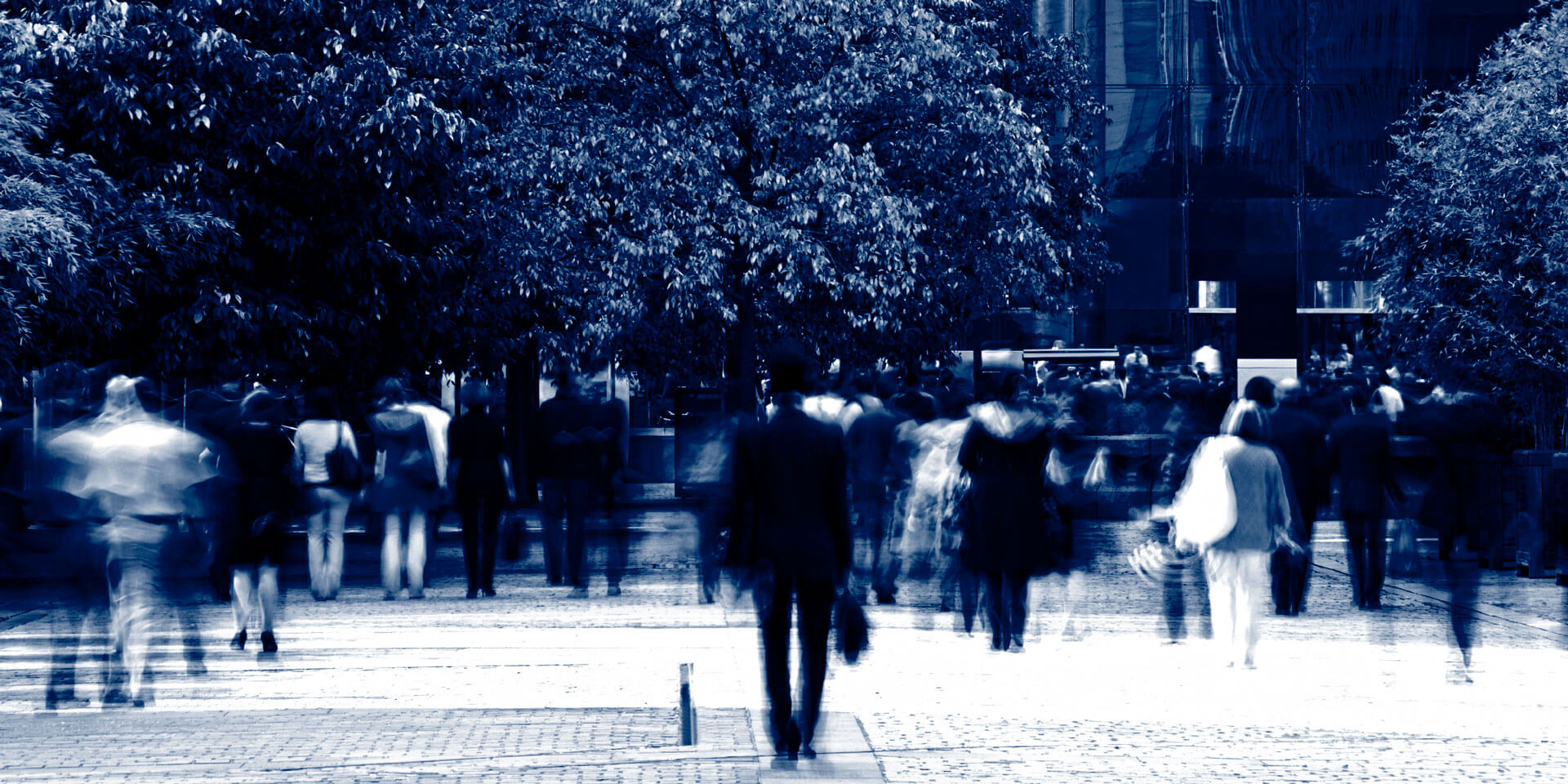 White collar professionals walking in busy financial district of city, blurred motion.