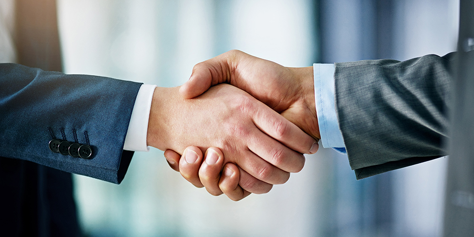 Photo of two hands embrace in a handshake,